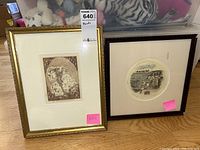 Two framed etchings side by side on floor showing different subjects - figures on horse and architectural scene