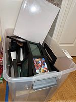 Bin filled with multiple hardwood black frames, various sizes including 4x6 and larger