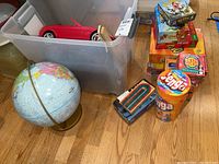 Overview shot showing globe, Jenga, Outburst Jr., assorted boxed games, plastic bin with red toy car, and small plastic horses