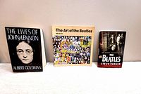 Front cover view of three Beatles music books - The Lives of John Lennon (hardcover), The Art of the Beatles (softcover), The Gossip According to The Beatles (softcover)