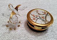 Hummingbird sculpture next to circular gold-rimmed Chokin pin dish with engraved bird and blossoms design