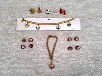 Full lot layout showing bracelet, cufflinks, pins, and necklace on a soft white textured surface.