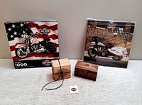 Harley Davidson puzzle box, 2016 calendar and wooden coaster set arranged in a row on white surface.