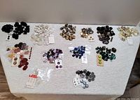 Top-down photo showing multiple groups of buttons sorted by color and style on white background