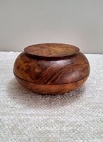 Side view of the vintage Bhutanese burl wood dhapa bowl showing its rounded shape and natural wood grain.