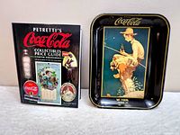 Photo showing the Coca Cola metal tray with Boy Fishing artwork by Norman Rockwell and the 1997 Petretti's Coca Cola Collectibles Price Guide book together.