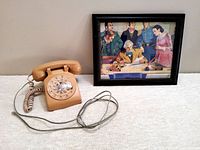 Vintage beige Northern Telecom rotary dial telephone and framed print of the first telegraph scene.