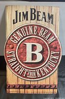Front view of the Jim Beam metal advertising sign showing the full design and wear.