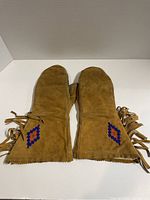 Front view of both gloves showing the brown suede leather and beaded diamond pattern near cuffs.