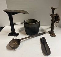 Overview of all five cast iron items: shoe anvil, cauldron, grinder/press, ladle, shoe form.