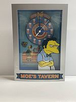 Front view of Moe's Tavern Simpsons beer clock showing Moe Szyslak and clock face with beer mug hour markers.
