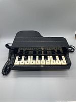 Front view of vintage grand piano phone showing piano key dial pad.