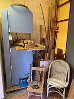 Full view of grey floor-standing band saw with wooden table surface and motor housing below