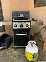 Full front view showing grill with propane tank and side shelves