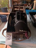 Front view of the bubble sextant in original case showing the main body, adjustment knobs and viewing scope.