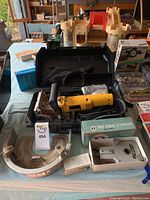 Wide view of DeWalt plate joiner and accessories on table with case and additional boxed items