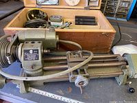 Unimat headstock mounted on bed rails with attached pulleys, tailstock and cross slide visible