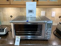 Front view of stainless steel toaster oven with control panel and LCD display