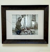 Full view of framed black and white WWI-era art print showing woman in uniform with greyhound dog and small medical supply cart toy.