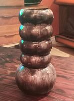 Side angle view of vintage pottery vase showing stacked bulbous form and brown drip glaze finish.