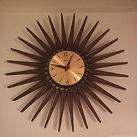 Front view of the vintage Syroco starburst clock showing full sunburst design and brass-colored metal dial.
