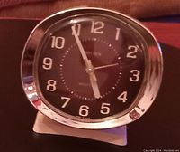 Front view of vintage Westclox Big Ben alarm clock showing oval face, brass-colored plastic frame, black dial with white numerals and hands.