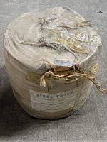 Full view of the large sisal twine reel wrapped in paper with label.