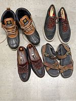 Overview of all four pairs of men's shoes including duck boots, casual sneakers, dress shoes, and sandals.