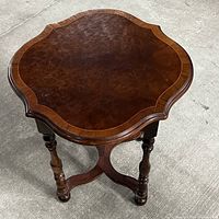 Top view showing the scalloped edges, polished wood grain surface of the vintage Edwardian table.