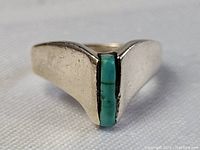 Close-up front view of sterling silver ring showing the raw turquoise slice in vertical setting with visible matrix pattern.