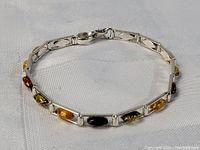 Full view of the sterling silver bracelet with amber stones arranged in rectangular links.