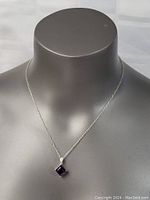 Full view of the sterling silver necklace with amethyst pendant on display bust.
