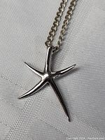 Close-up of sterling silver starfish pendant with polished finish showing shape and texture.