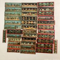 Overview of 37 hand painted magic lantern slides arranged in rows, showing a variety of scenes and colors. Some slides include multiple frames or circular vignettes within the glass slide.