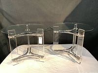 Two side tables side by side on white cloth against dark backdrop