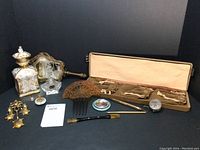 Overview of the full lot: assorted vanity items including bottles, compact, hair comb, earrings, hand mirror, jewelry case and powder box.