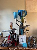 Full bench overview showing Dillon SL 900 press, Hornady press, powder meters, manual, storage box and accessories