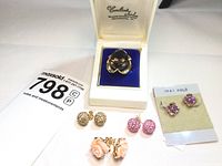 Overhead view of ring in box and four pairs of stud earrings with lot card