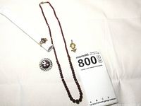 Overview of all four jewelry pieces together showing necklace, pendant, brooch and ring