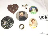 Lot of 10 miniature hand painted portrait medallions and pins in various shapes and colors on plain white background