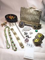 Overall display of all 16 pieces showing bracelets, necklace, brooches, earrings, shoe buckles, purse, and box.