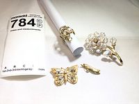 Overview of all four jewelry pieces placed with lot tag