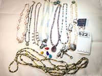 Overview of multiple vintage necklaces with varied pearls, beads, pendants, and Milor earrings