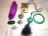 Full lot photo showing seven pieces of vintage Chinese jade and mixed stone jewelry including brooches, necklace, bracelet, and fabric pieces.