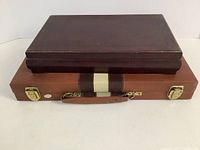 Closed view of two game cases stacked, showing leather and wood textured exterior finishes.