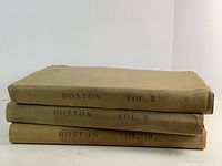 Stack of three volumes labeled Boston Vol. 2, Vol. 8, and Vol. 10, showing beige cloth covers and some wear