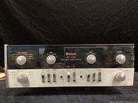 Front view of McIntosh MA 5100 preamp amplifier chassis showing input selector, bass, treble, mode selector, sliding switches and headphone jacks