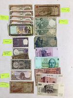 Assorted Macau, India, UAR, Syria, Lebanon and Israel banknotes laid out on white surface