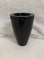 Full front view of tall black vase with geometric design near the top rim