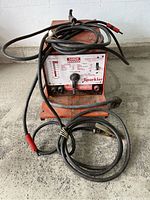 Front view of welding machine with cables draped over unit